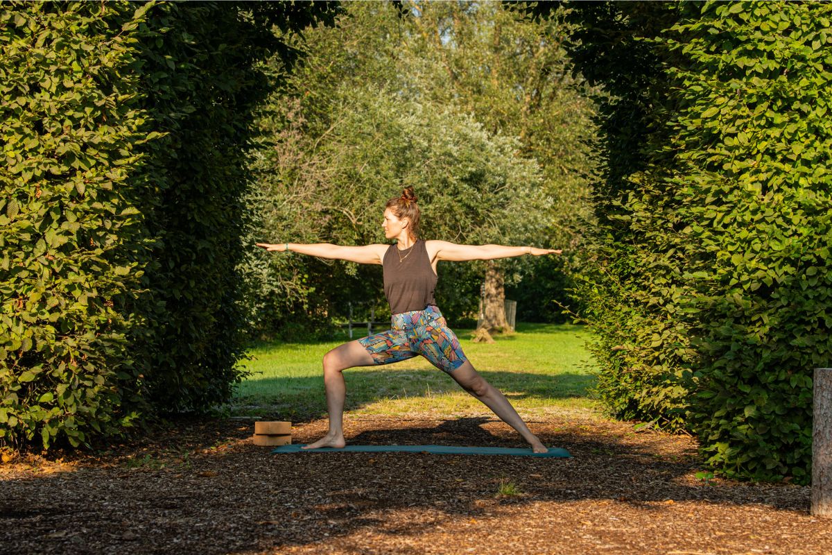 Frau macht Krieger 2 bei Yoga fürs Skitourengehen