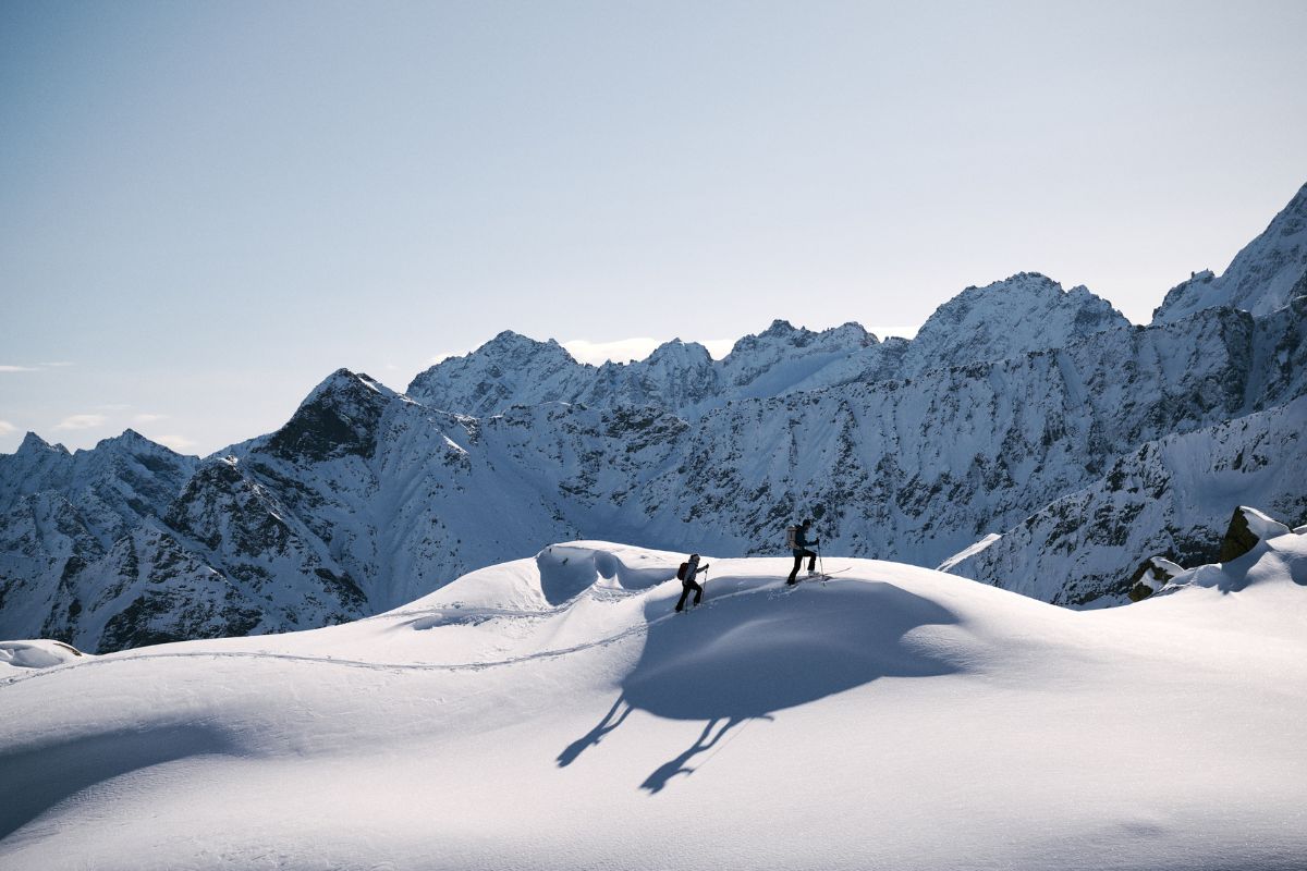 Ski tourers ascending in front of a mountain backdrop