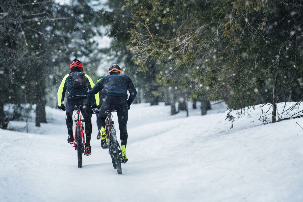 Zwei Mountainbiker auf schneebedecktem Weg
