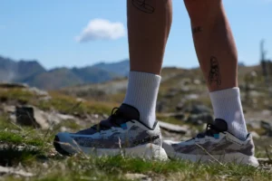 Salomon Schuhe stehen auf felsigem Untergrund bei einer Gravel Running Tour in den Bergen.