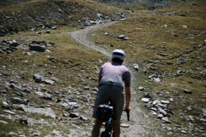 Eine Person fährt mit dem Bikepacking-Rad auf einem steinigen Bergtrail.