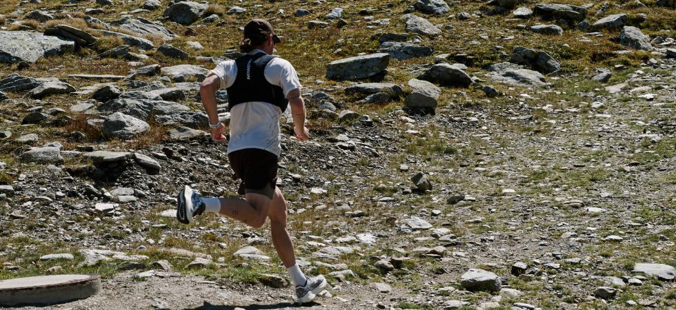 Ein Läufer bewegt sich beim Gravel Running über einen steinigen Bergpfad.