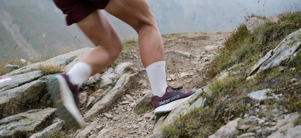 Nahaufnahme von Trailrunning Schuhen beim Laufen auf einen Berg.