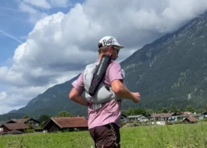 Ein Läufer läuft mit Trailrunning Rucksack durch ein Bergtal.