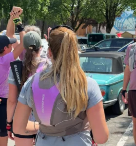 The rear view of a runner highlights the fit of the hydration vest during a group run.