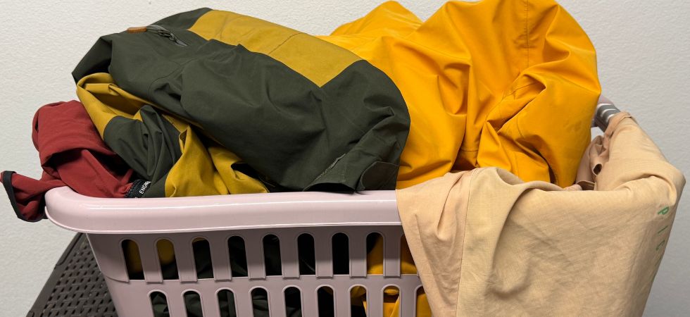 Outdoor clothing in a laundry basket before washing.
